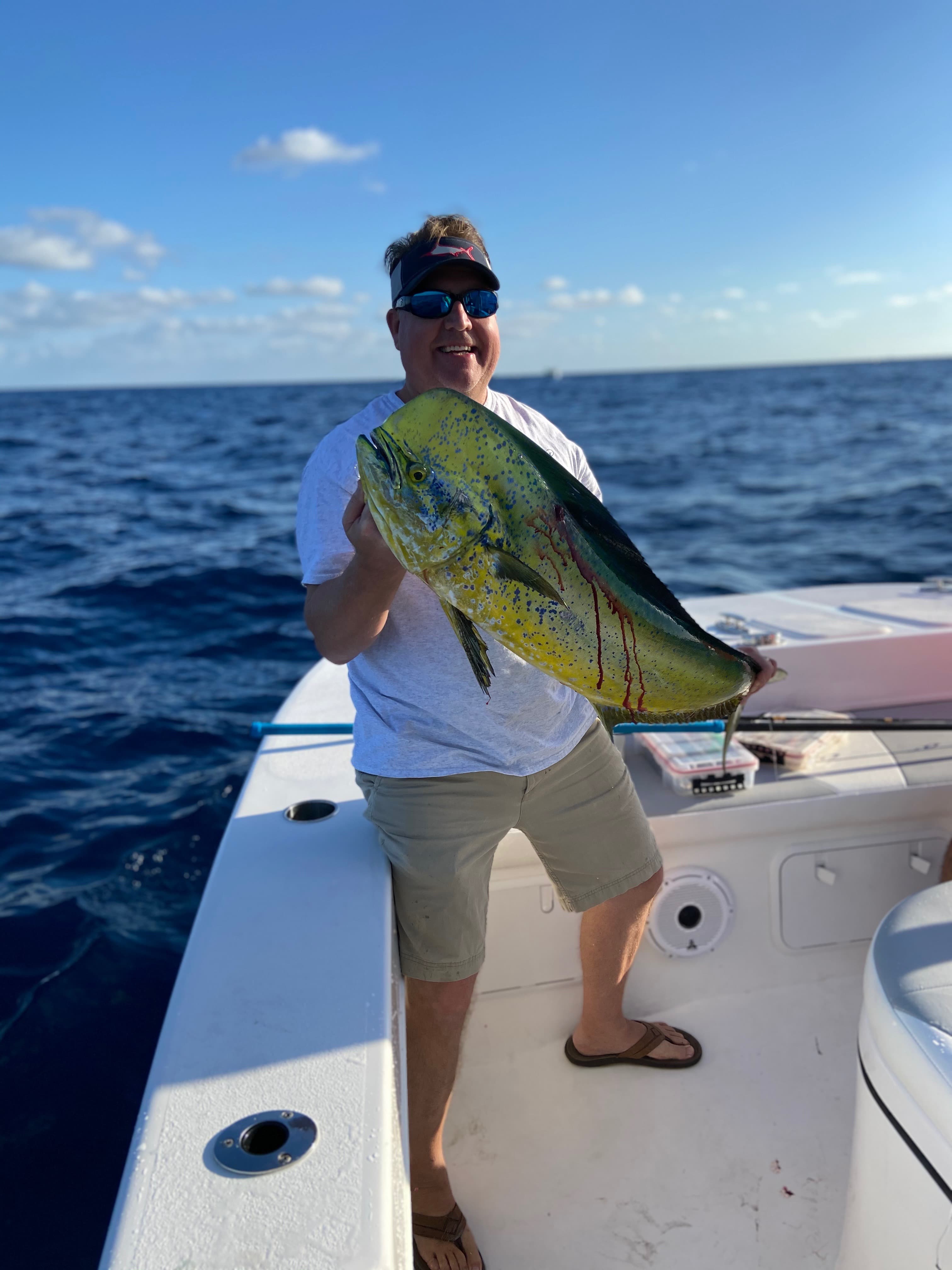 Jerry Jackson holding a mahi-mahi catch on a fishing boat off the Florida coast