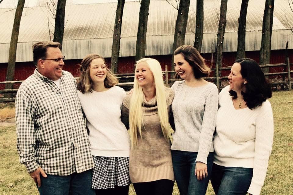 Jerry Jackson with his wife and three daughters in front of a barn